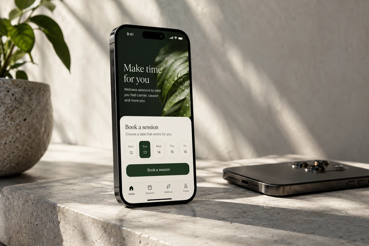Wellness booking app open on a smartphone beside a plant and wireless earbuds
